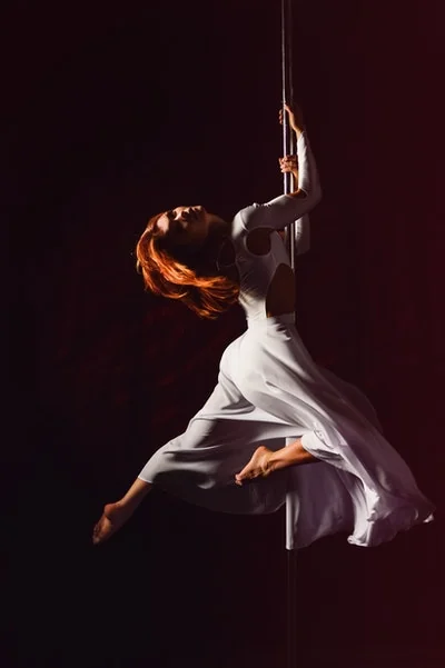 Adults learning pole at a weekly dance class in Nottingham